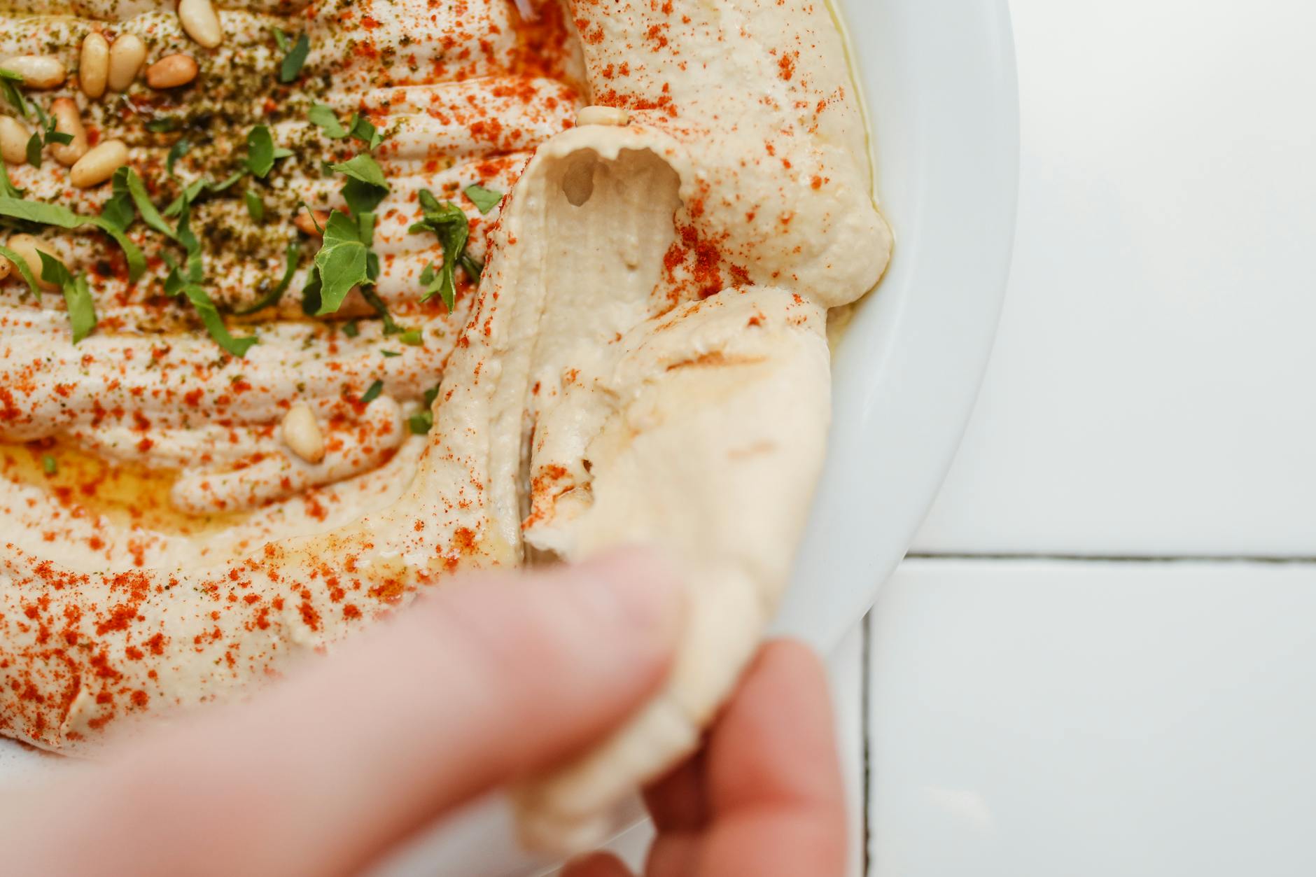 Tearing pita bread to scoop hummus at a Jerusalem restaurant