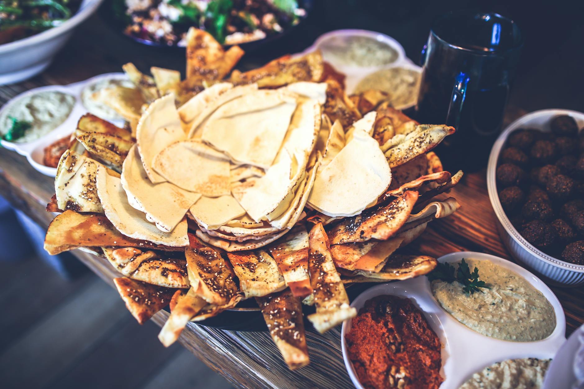 Spread of traditional Jerusalem food dishes including hummus, mezze, salads and warm pita