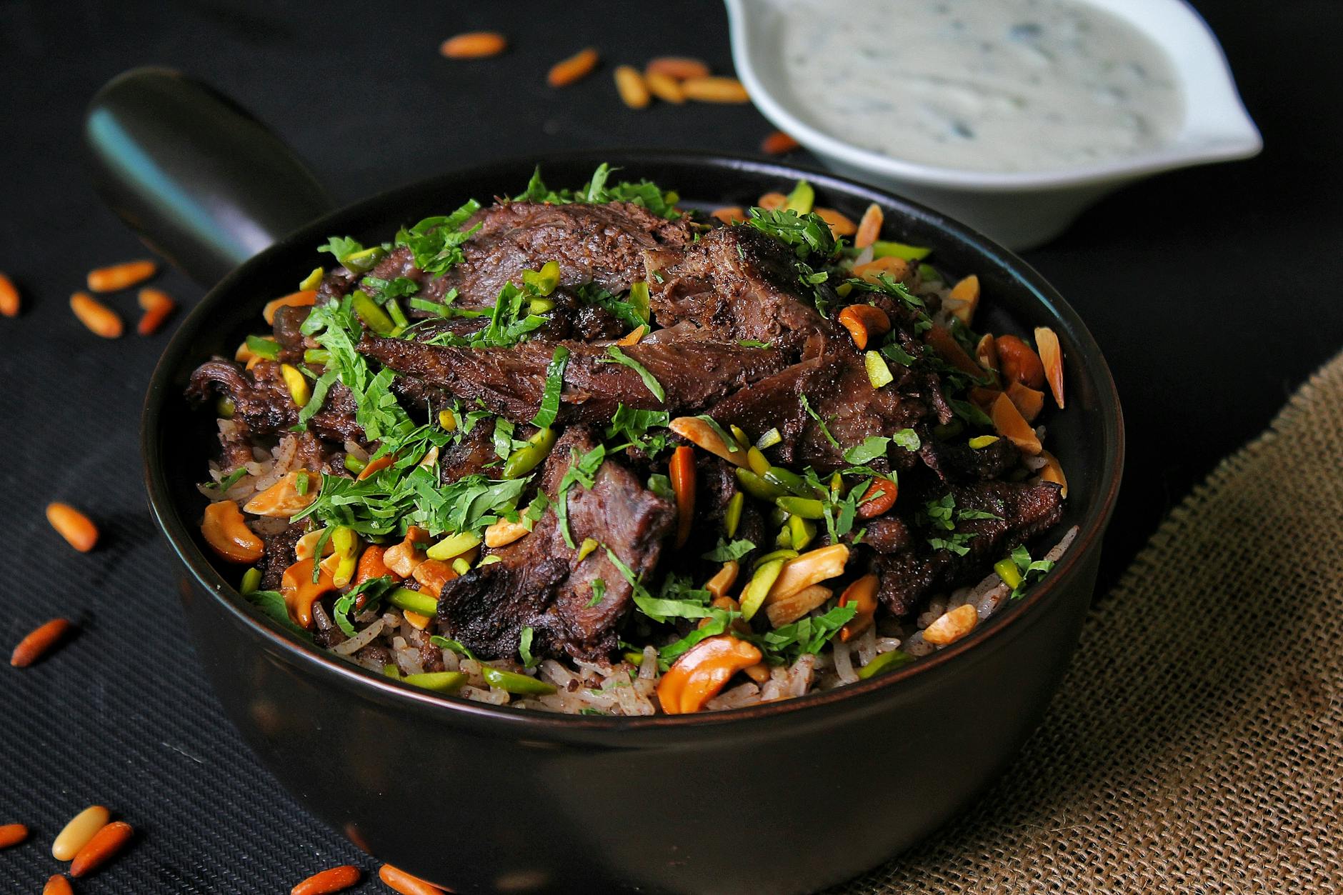 Traditional Levantine rice and meat dish served on a platter with herbs and pine nuts