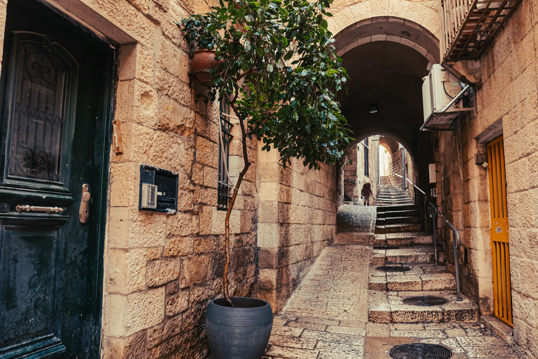 Walking through a quiet Jerusalem neighborhood with restored stone houses and gardens
