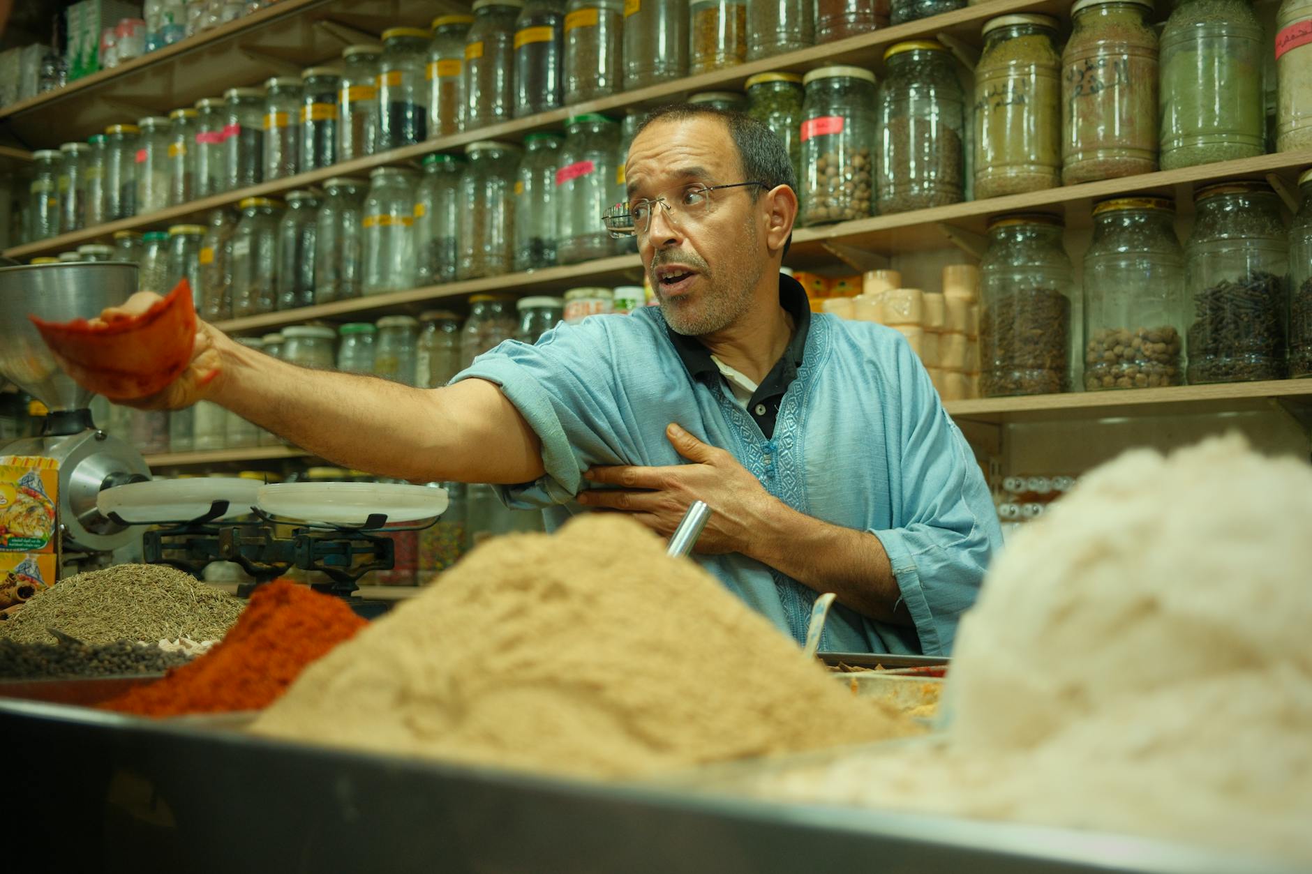 Spice merchant in Jerusalem Old City market with mountains of colorful spices