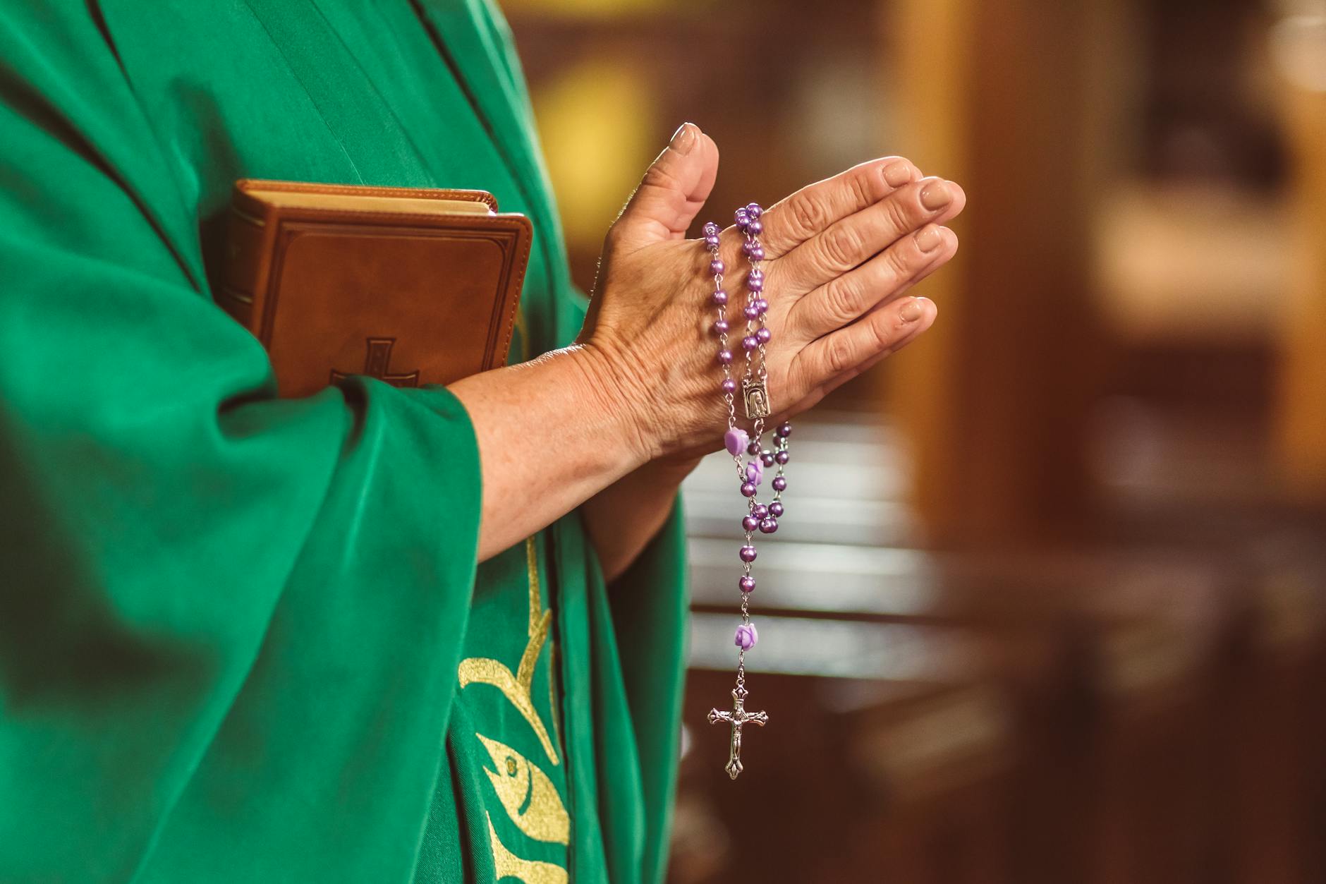 Pilgrim with rosary praying at Christian holy site in Jerusalem