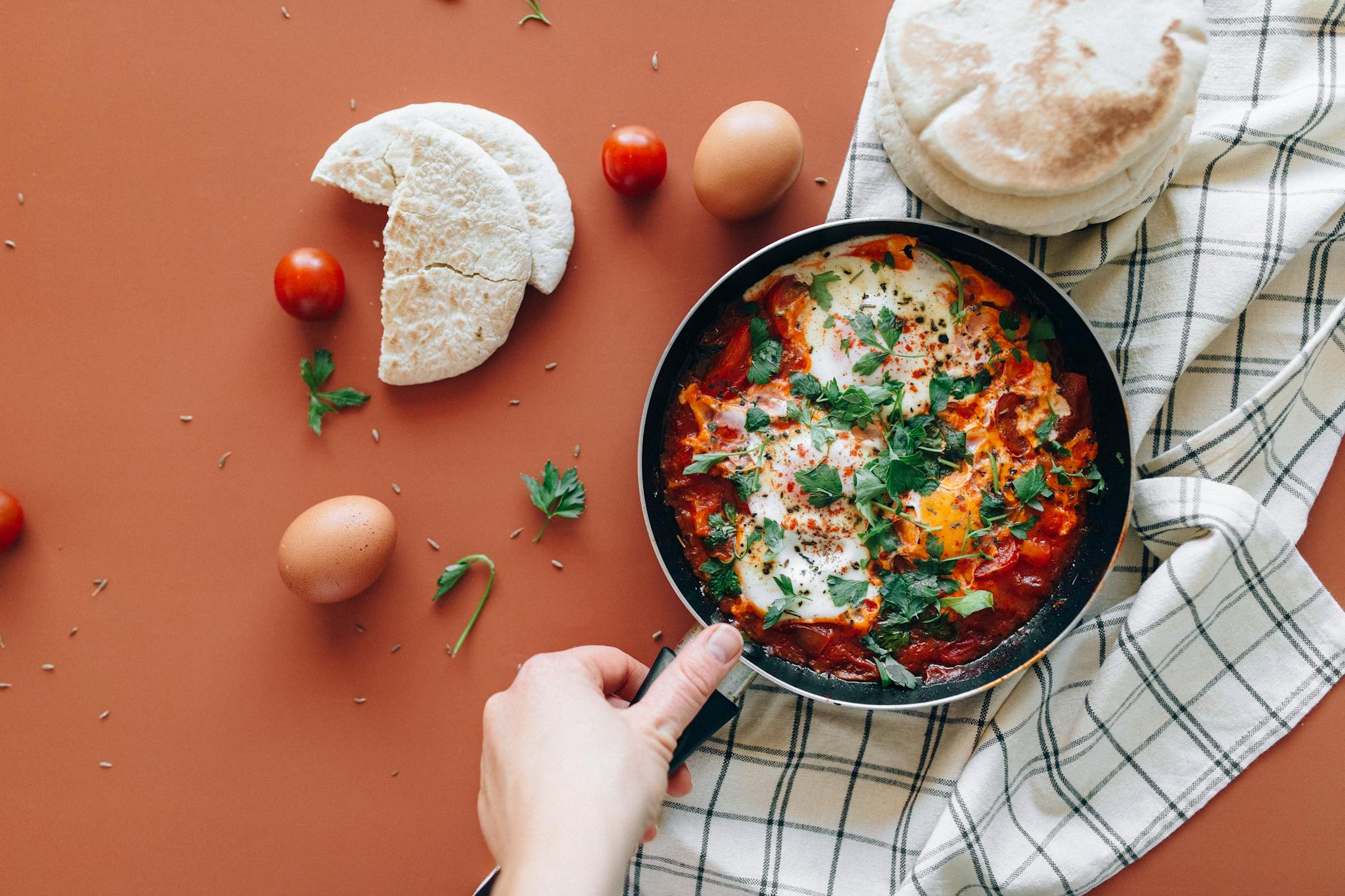 Vegan shakshuka with tomato sauce, fresh herbs and warm pita bread