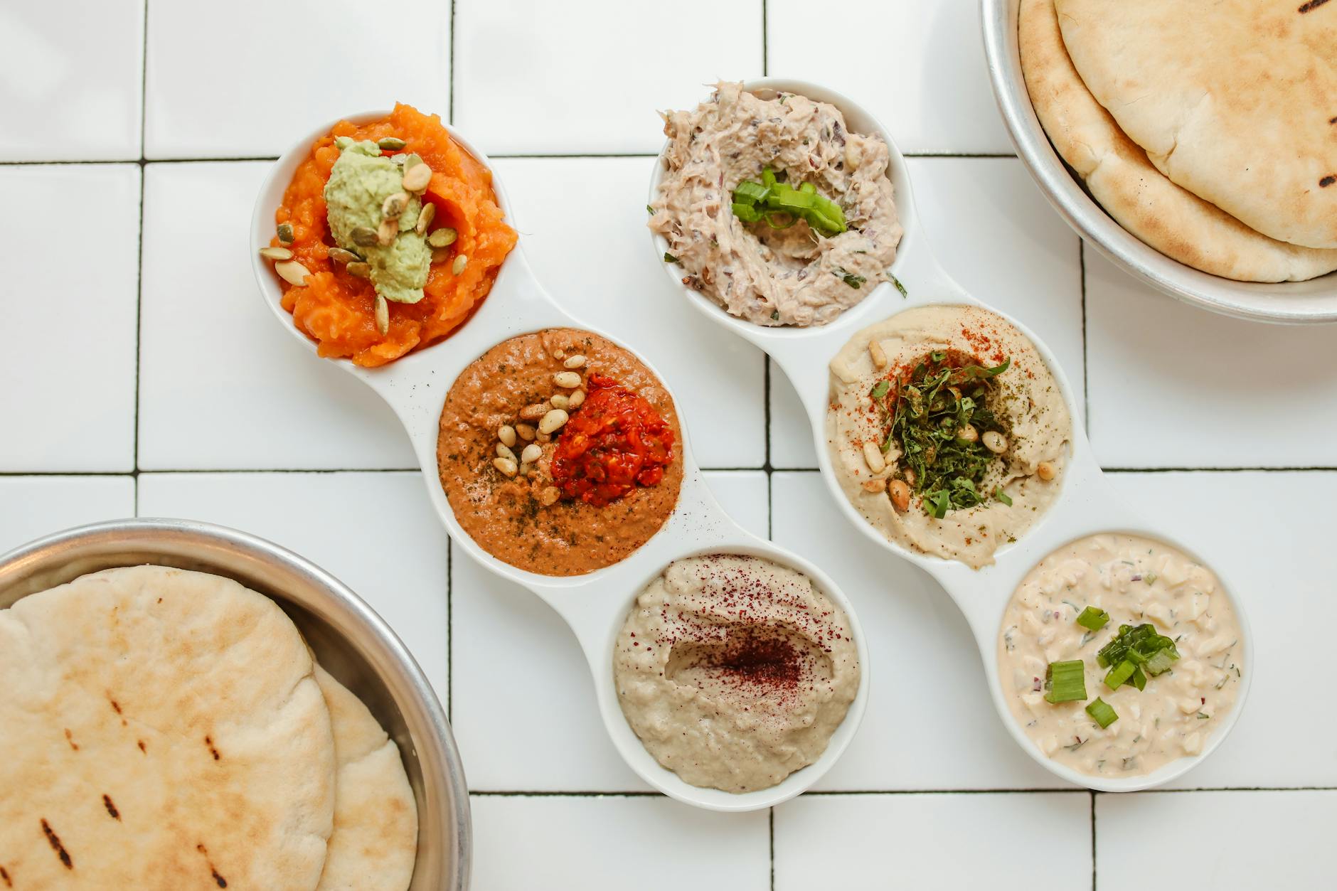 Plant based mezze spread with hummus, vegetables, olives and pita bread