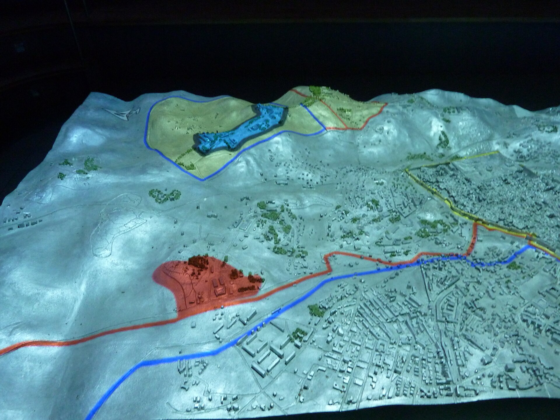 An illuminated relief model of Jerusalem in the Ammunition Hill museum, with areas of the divided city outlined in blue, red and yellow