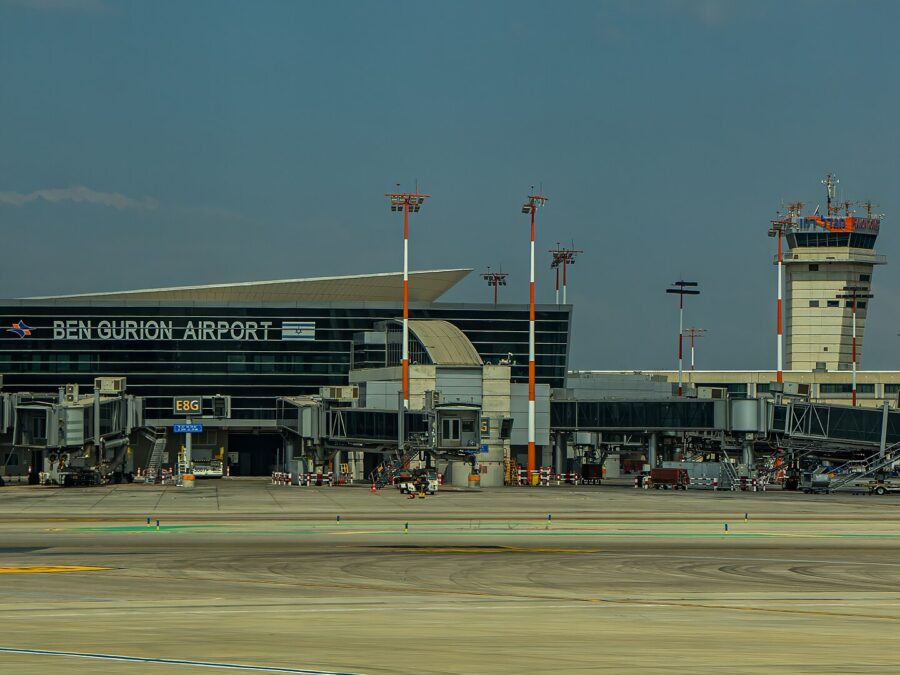 Ben Gurion Airport's Terminal 3 seen across the apron, with Ben Gurion Airport lettering on the facade, jet bridges, floodlight masts and the control tower