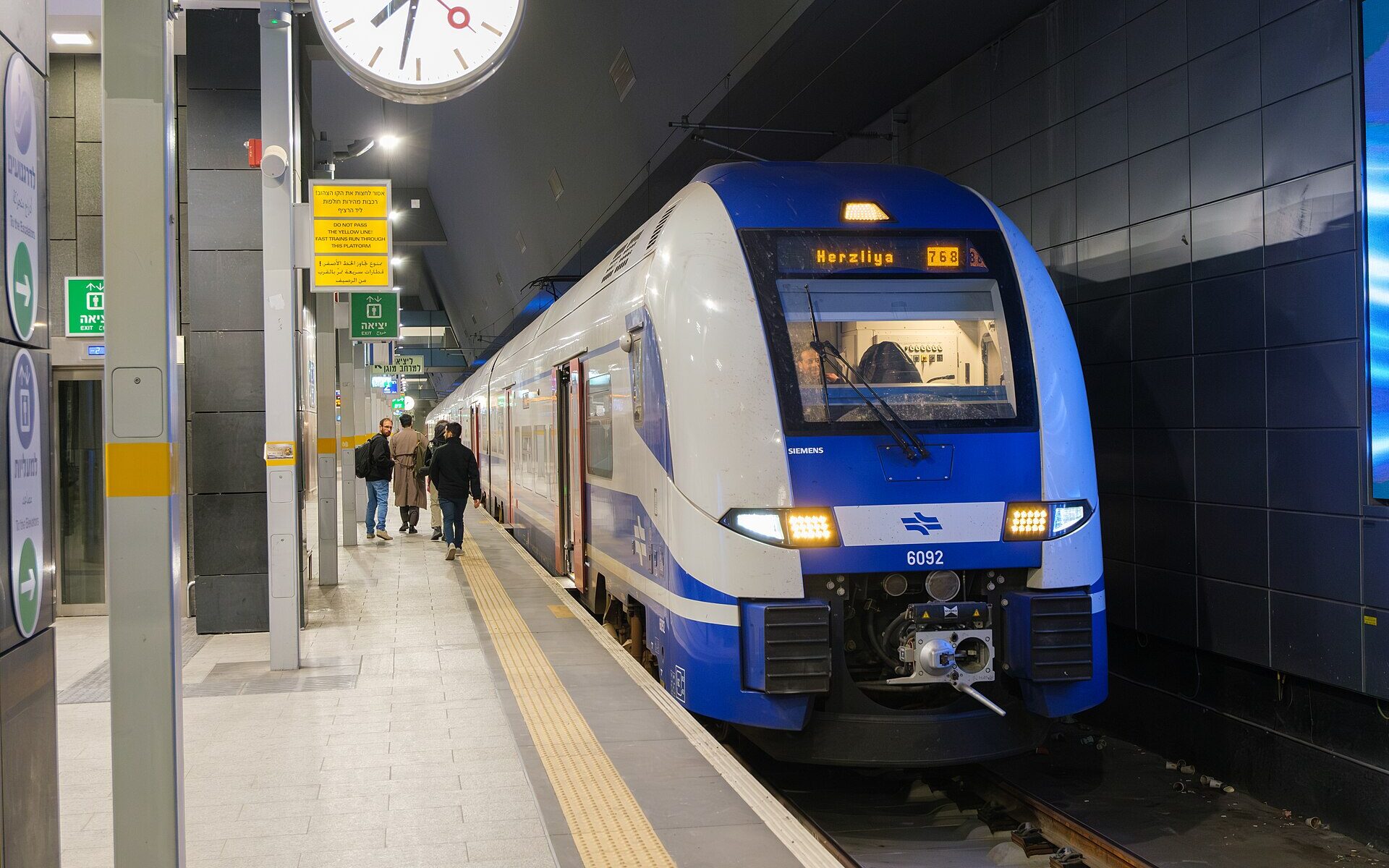 Blue and white Israel Railways Siemens electric train showing Herzliya on its destination display at an underground platform of Jerusalem–Yitzhak Navon station