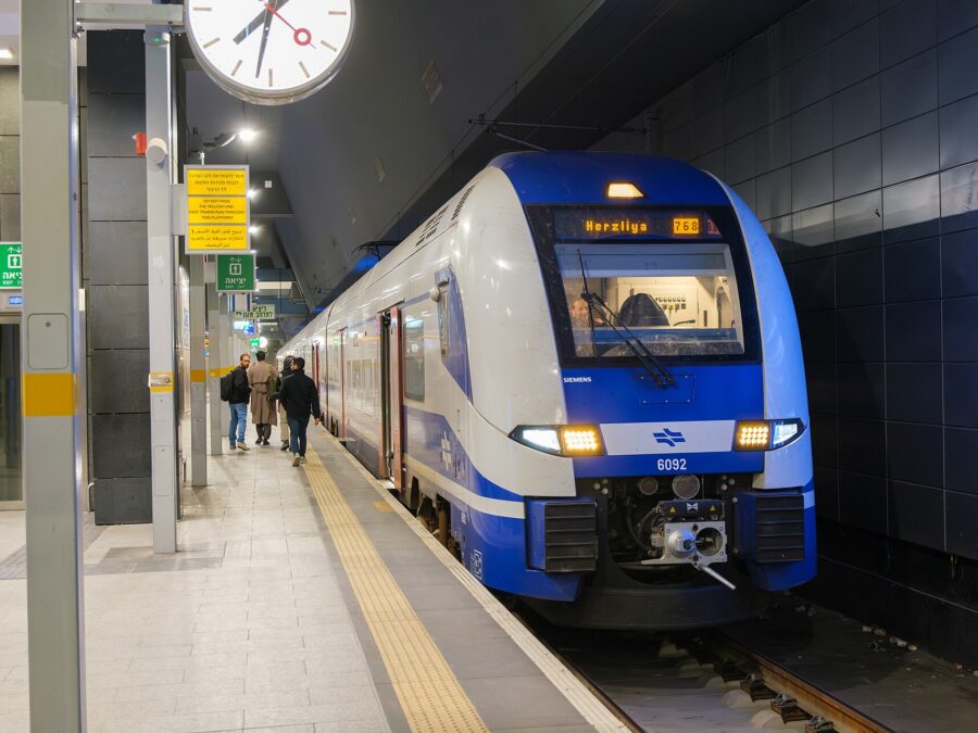 Blue and white Israel Railways Siemens electric train showing Herzliya on its destination display at an underground platform of Jerusalem–Yitzhak Navon station