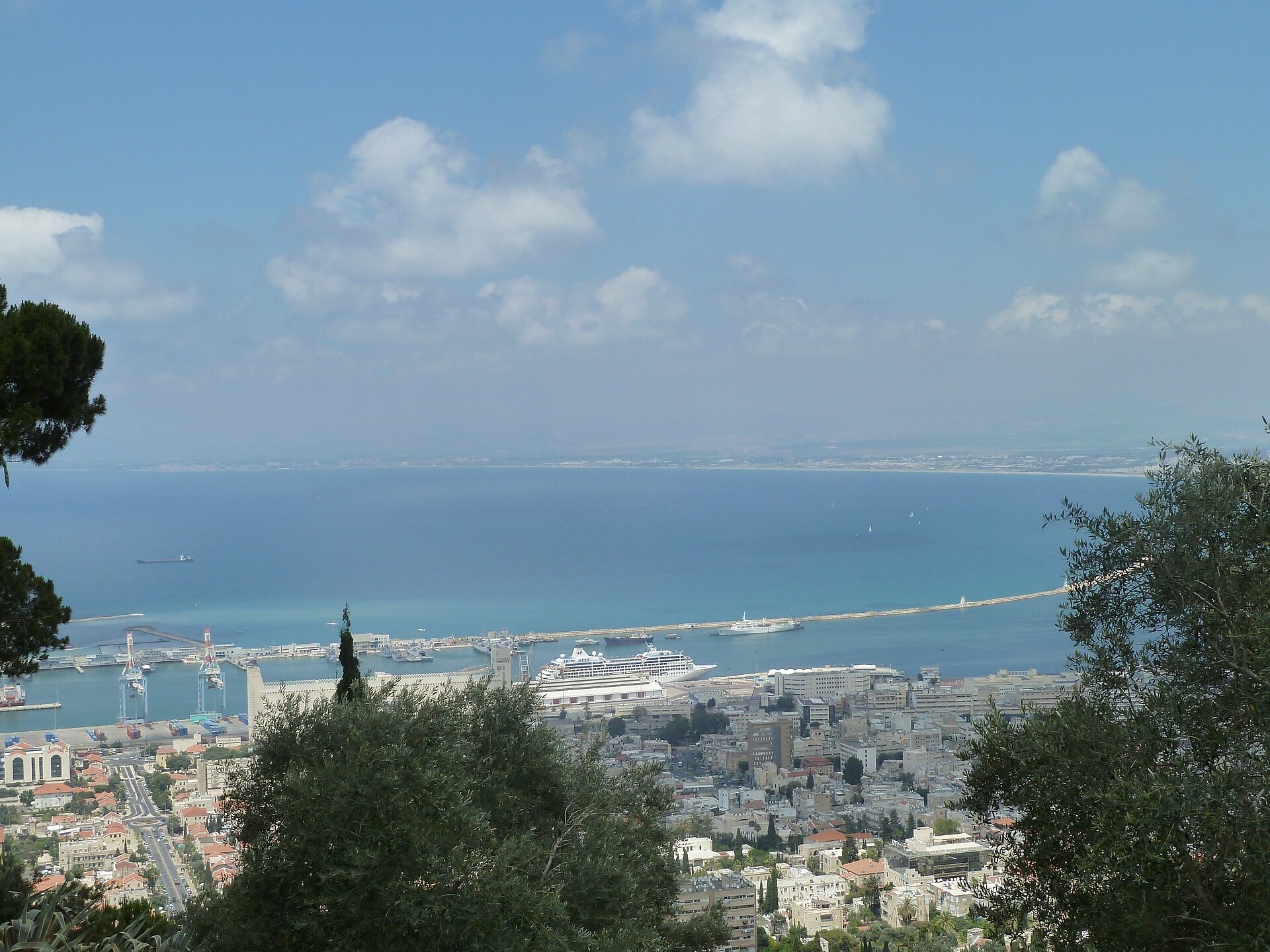 View from the Bahá'í Gardens on Mount Carmel over Haifa's lower city and port, with a cruise ship berthed and Haifa Bay stretching north