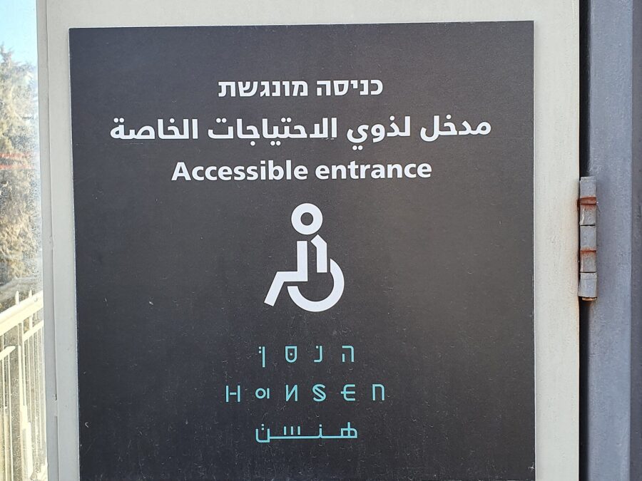 A Hebrew, Arabic and English 'Accessible entrance' sign with a wheelchair symbol at Hansen House in Jerusalem