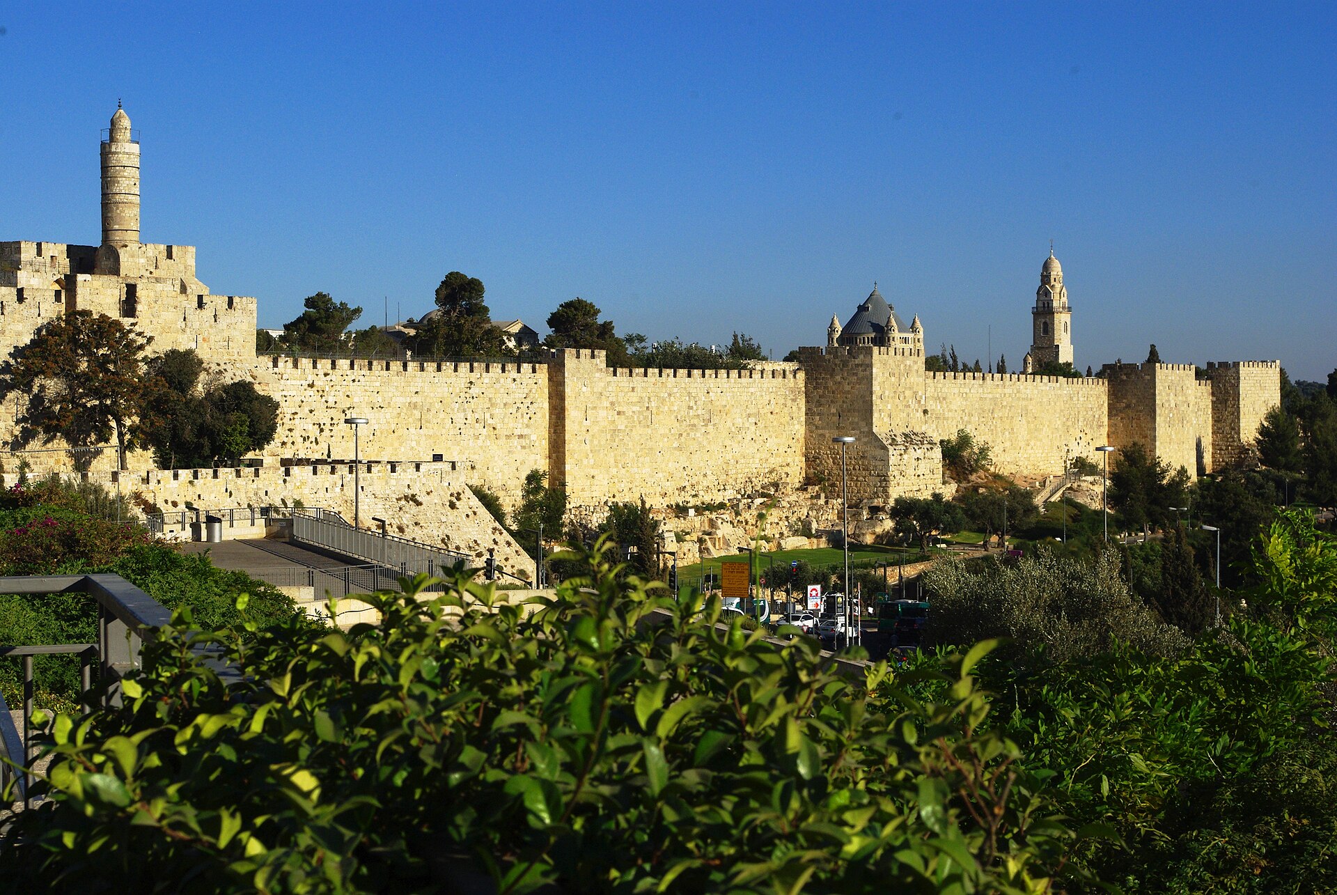 Jerusalem's crenellated Old City wall stretching from the Tower of David and its minaret to Mount Zion, where the Dormition Abbey's dome and bell tower rise behind