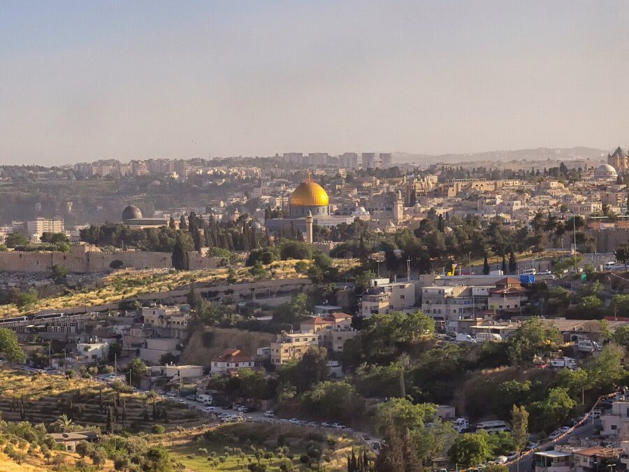 Late-afternoon sun warms Jerusalem's Old City walls, the grey dome of Al-Aqsa Mosque and the golden Dome of the Rock above hillside houses and olive terraces