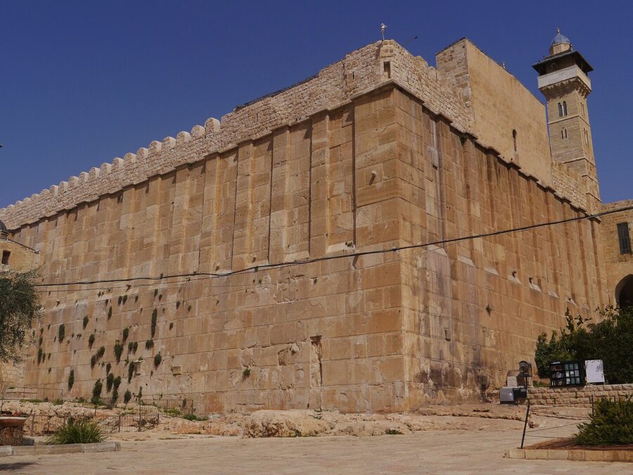 The massive Herodian stone enclosure of the Cave of the Patriarchs, also known as the Ibrahimi Mosque, in Hebron, with crenellated walls and a minaret at each end