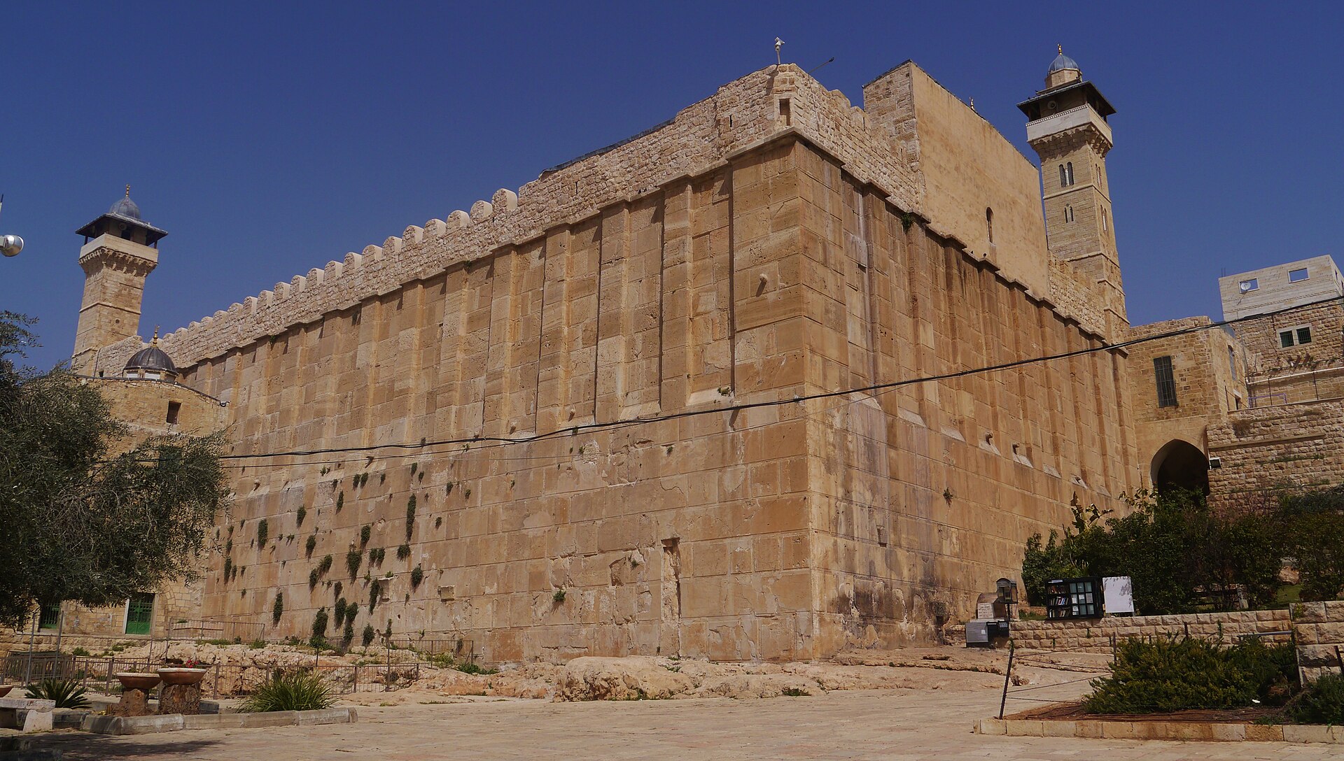 The massive Herodian stone enclosure of the Cave of the Patriarchs, also known as the Ibrahimi Mosque, in Hebron, with crenellated walls and a minaret at each end