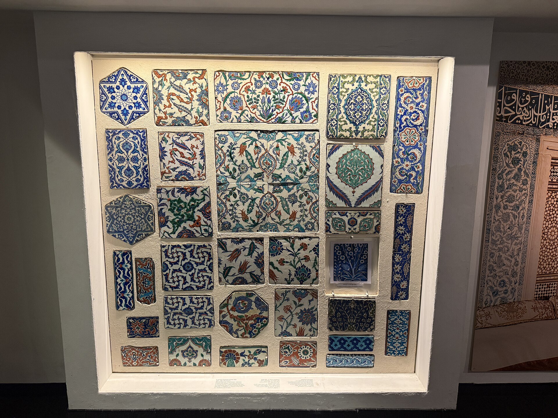 A wall display of blue, turquoise, green and red glazed ceramic tiles with floral and star patterns at the Museum for Islamic Art in Jerusalem