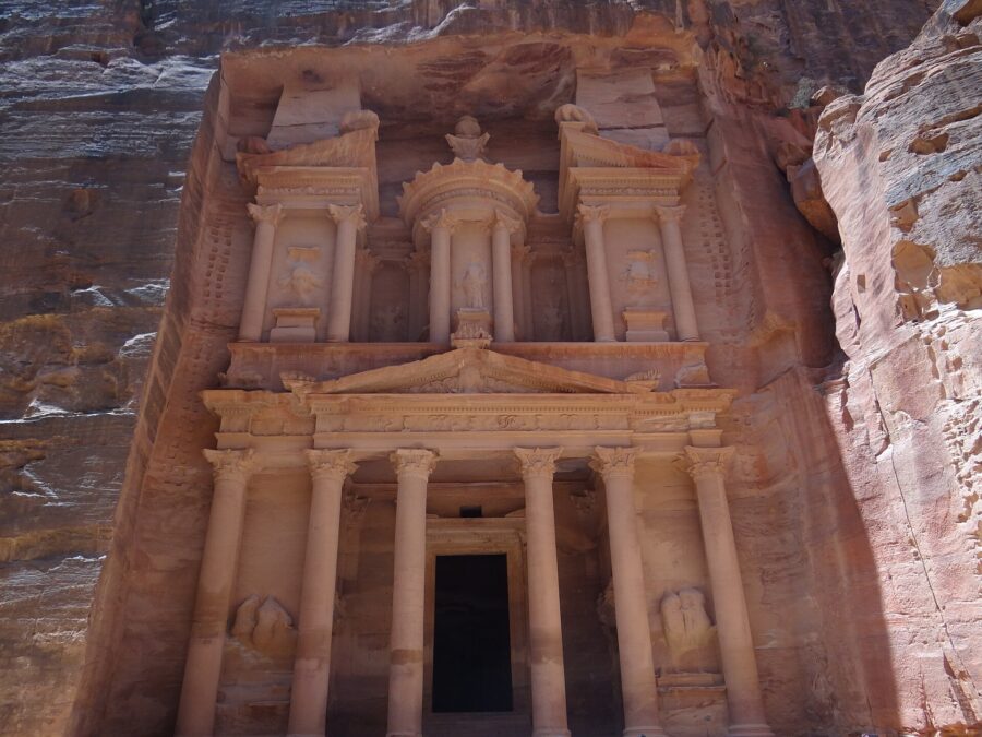 The rose-red carved facade of Al-Khazneh, the Treasury, at Petra in Jordan, with columns, pediments and statues cut into the sandstone cliff
