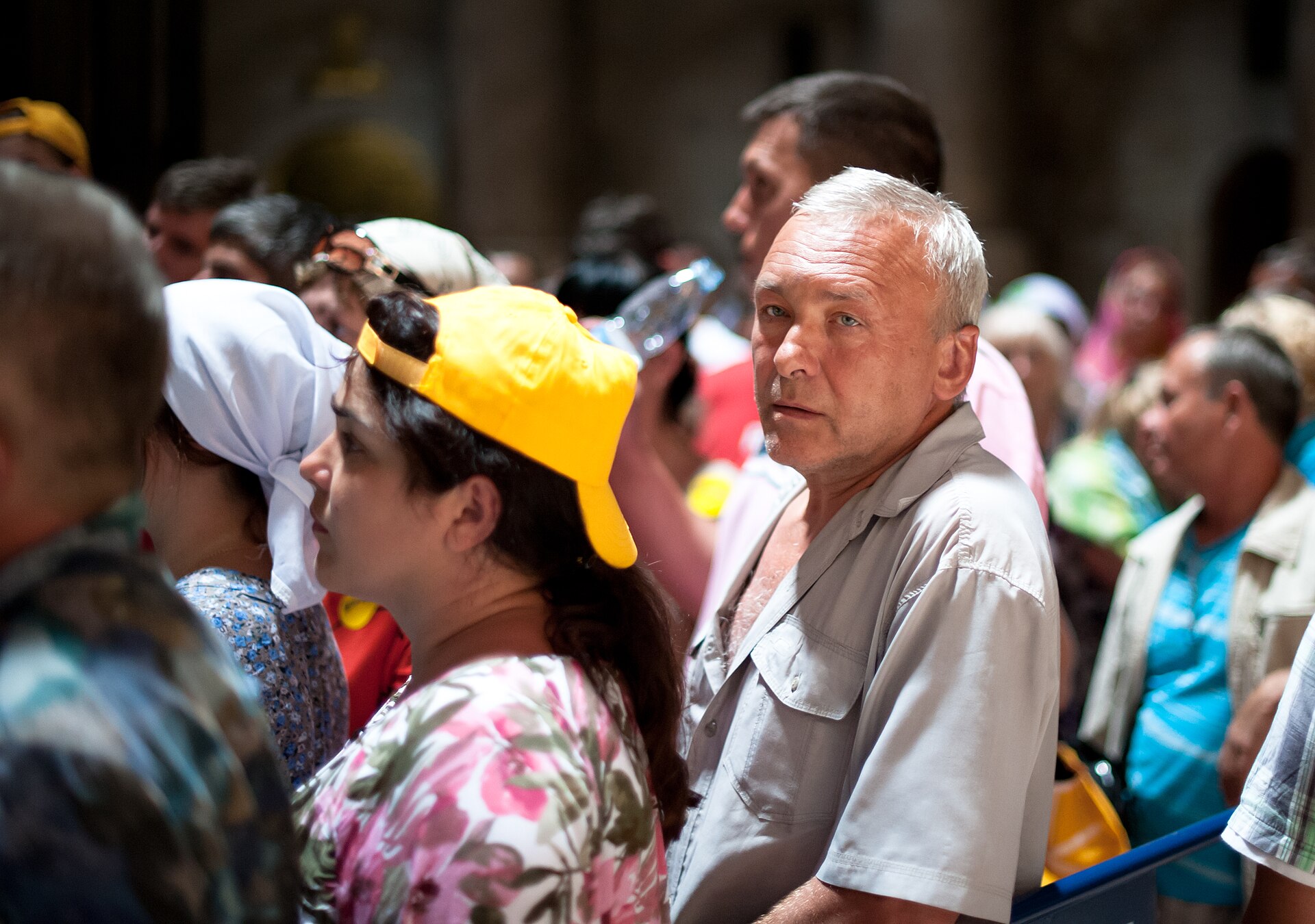 A crowd of pilgrims standing close together inside the Church of the Holy Sepulchre, waiting in line to enter the Edicule