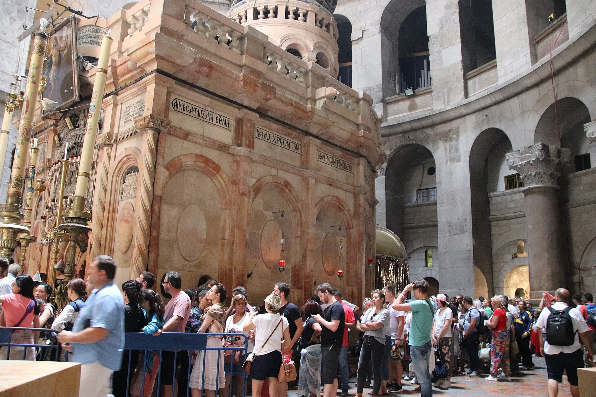 The restored Aedicule over the traditional tomb of Jesus in the Rotunda of the Church of the Holy Sepulchre, with visitors queuing behind barriers beneath arched galleries