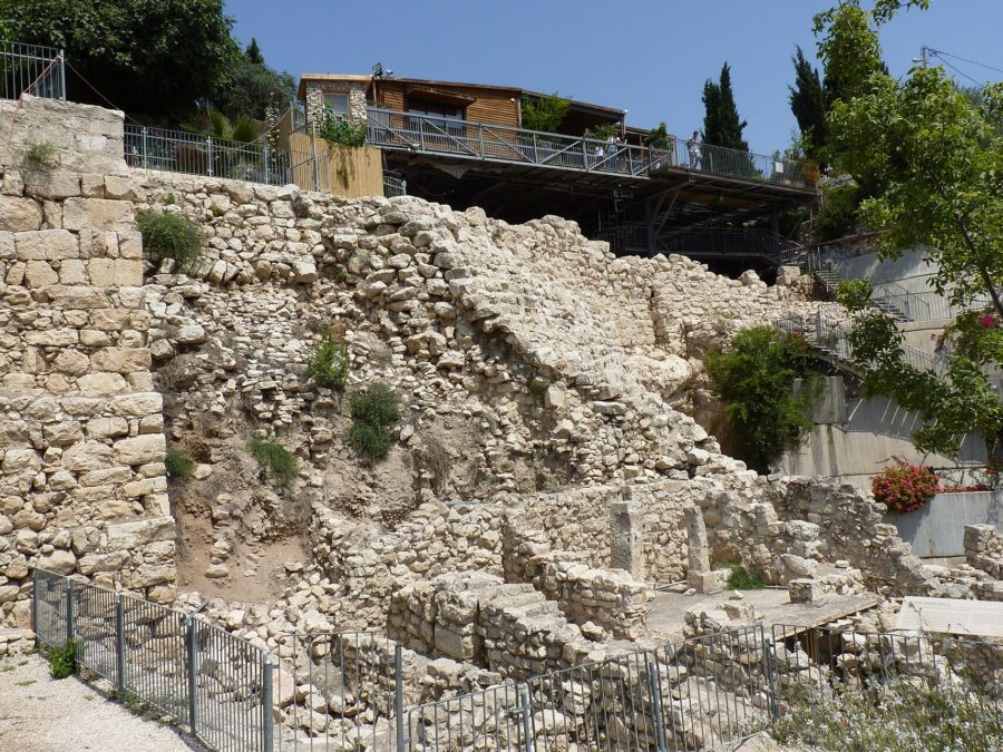 The Stepped Stone Structure in the City of David, a steep terraced stone slope above excavated Iron Age house walls and pillars, with a viewing deck above