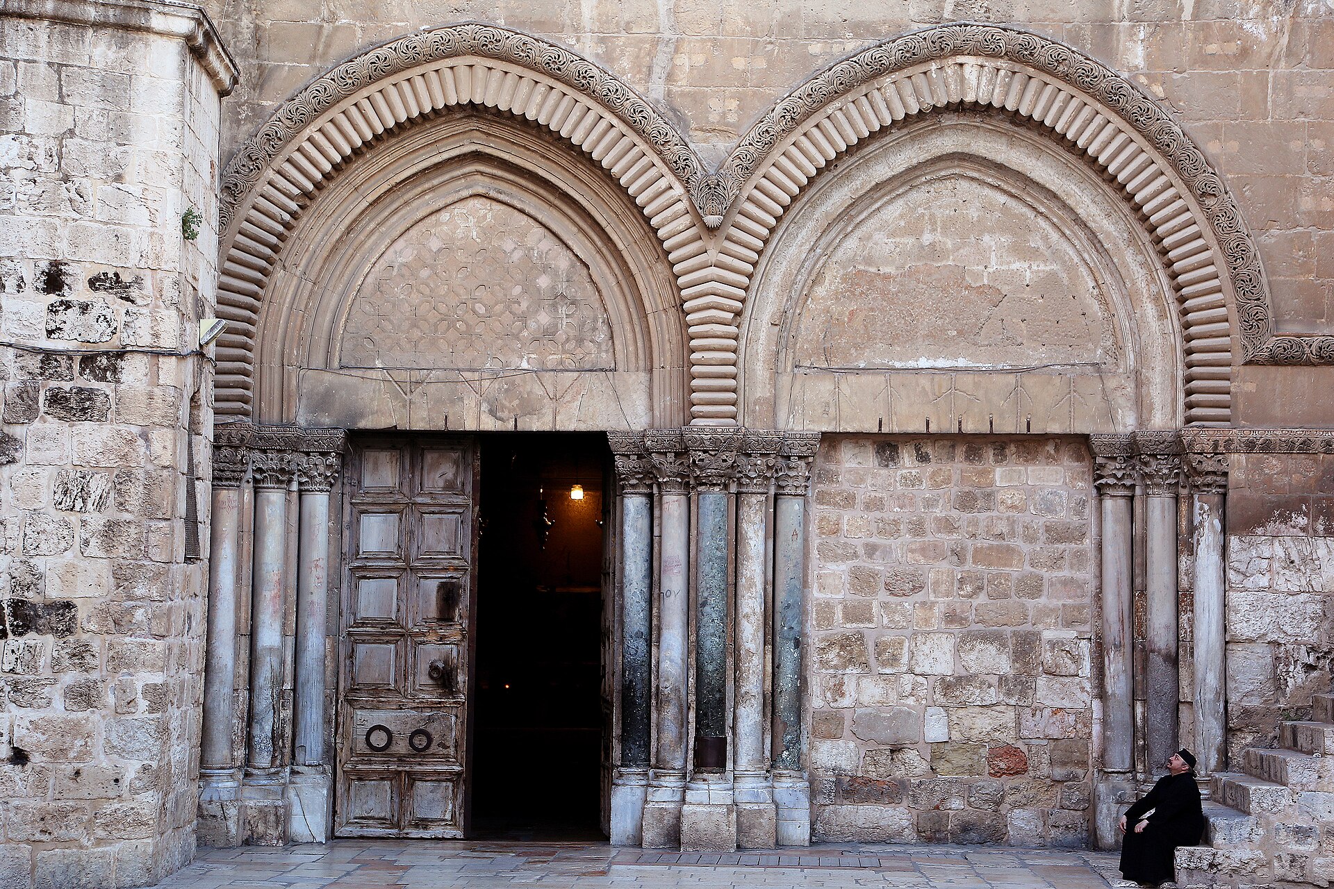 Twin pointed Crusader doorways of the Church of the Holy Sepulchre, with carved archivolts over clustered marble columns, one door open and one walled up