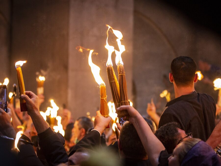 Worshippers raising blazing bundles of candles lit from the Holy Fire inside the Church of the Holy Sepulchre in Jerusalem on Orthodox Holy Saturday