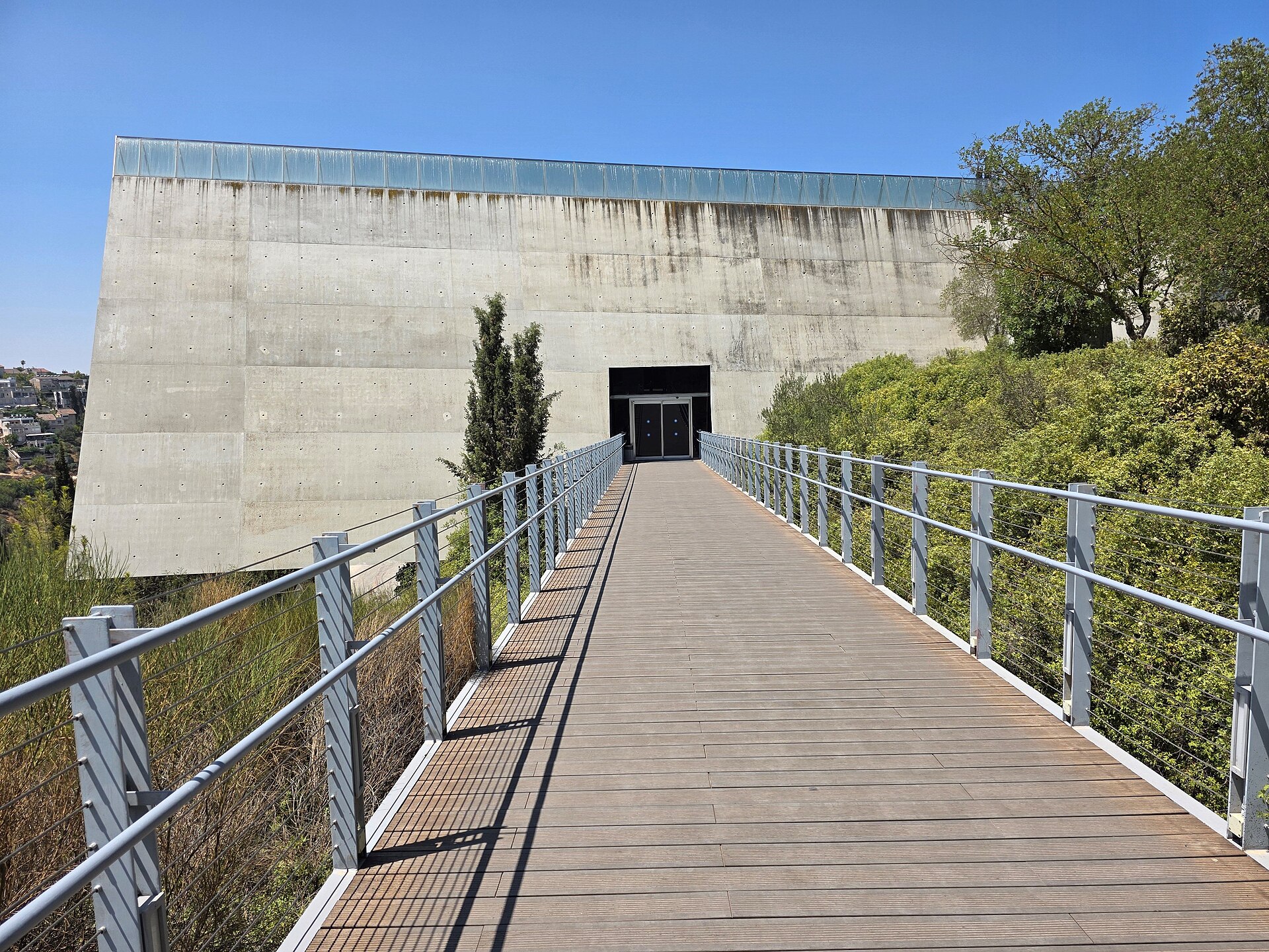 A wooden footbridge leading to the doors in the triangular concrete end wall of the Holocaust History Museum at Yad Vashem in Jerusalem