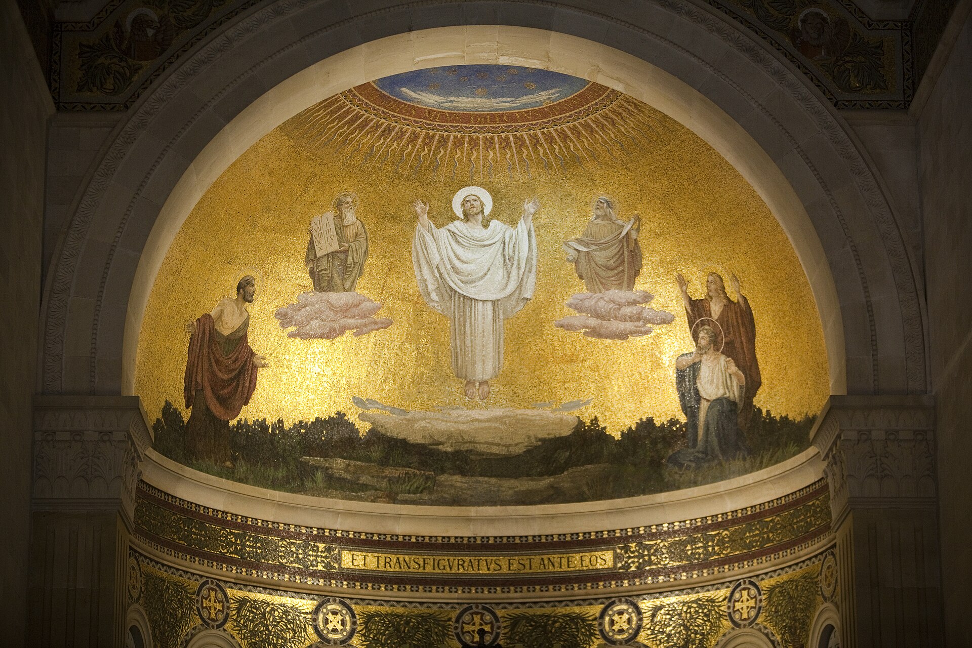 A gold apse mosaic showing the transfigured Christ in white robes, with figures on either side, inside a church